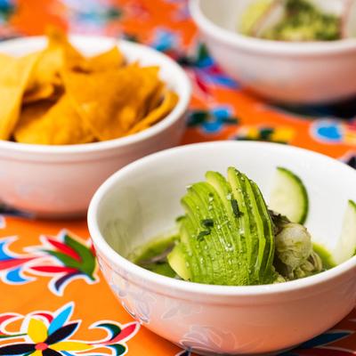 Spicy shrimp ceviche with cucumber, onion, and avocado, served with tortilla chips.