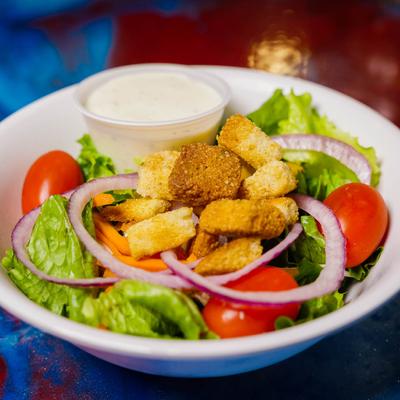 Salad with lettuce, cherry tomatoes, red onion and croutons, served with dressing.
