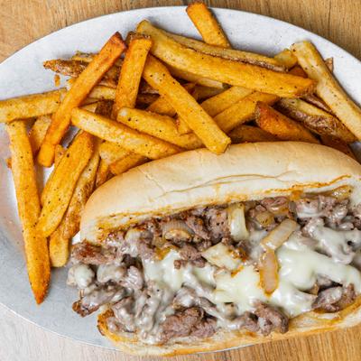 Philly cheesesteak served with fries.