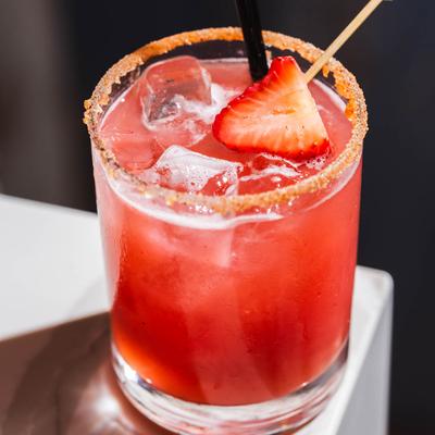 Red That's Spicy Cocktail, chili salt rim, garnished with a strawberry.