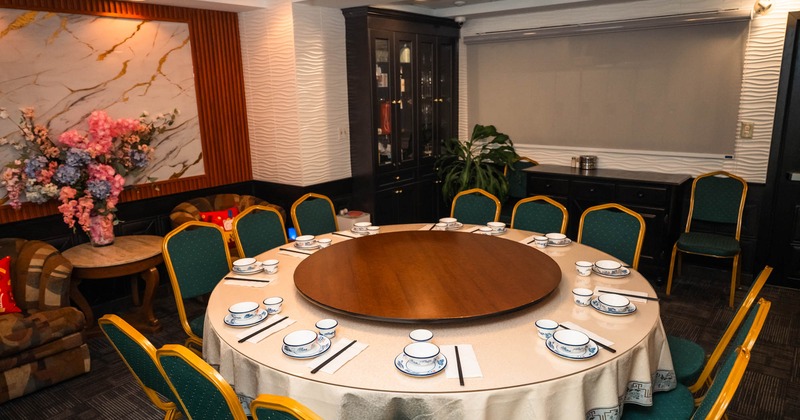 Interior, private dining area, white cloth round table for twelve people, ready for guests