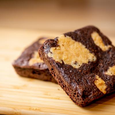 Couple of brownies, served on the wooden board.