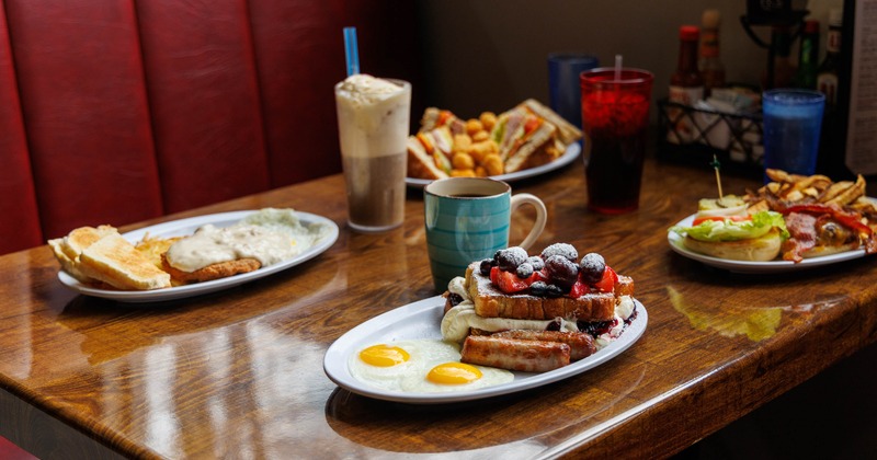 Various breakfast plates served on the table with drinks