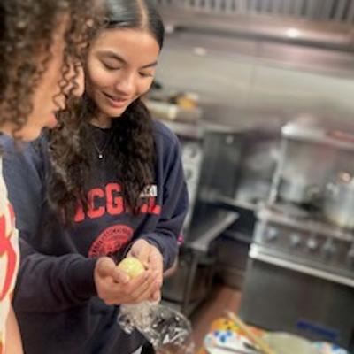 Two people peeling onions in the kitchen
