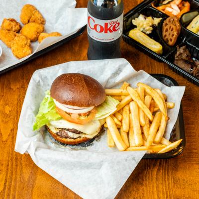 Double Cheeseburger served with fries, bottle of diet soda and other dishes.