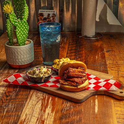 Sliced chicken sandwich and side dishes.