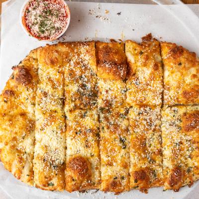 Cheesy garlic breadsticks with a side of marinara sauce.