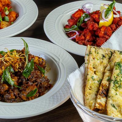 Mixed dishes including chicken pepper fry, chicken 65, and naan.