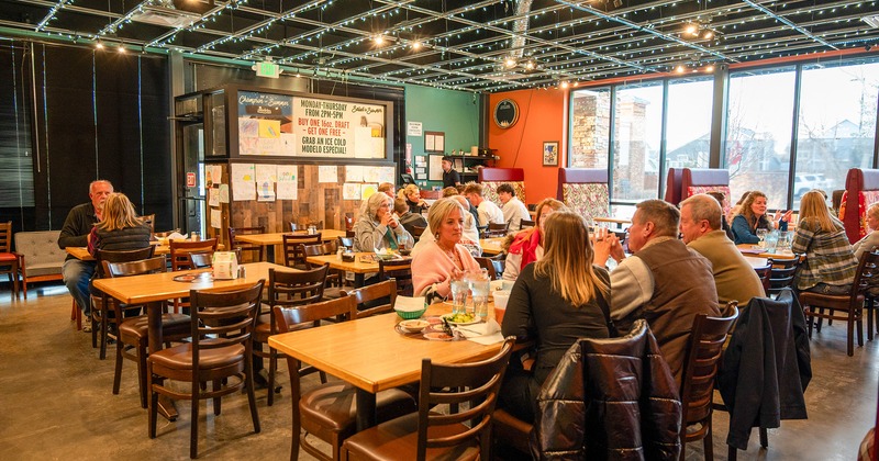 Restaurant interior, dining area with guests chatting and enjoying their food and drinks