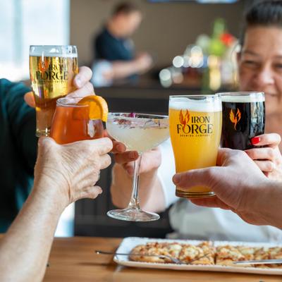 Group of people clinging glasses with beer and cocktails.
