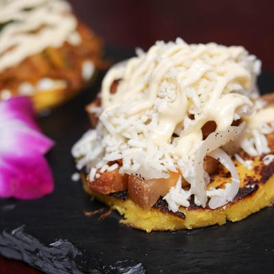 Pork belly cachapa, topped with cheese.