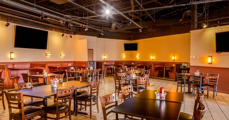 Interior, tables and chairs, tv screens on the walls