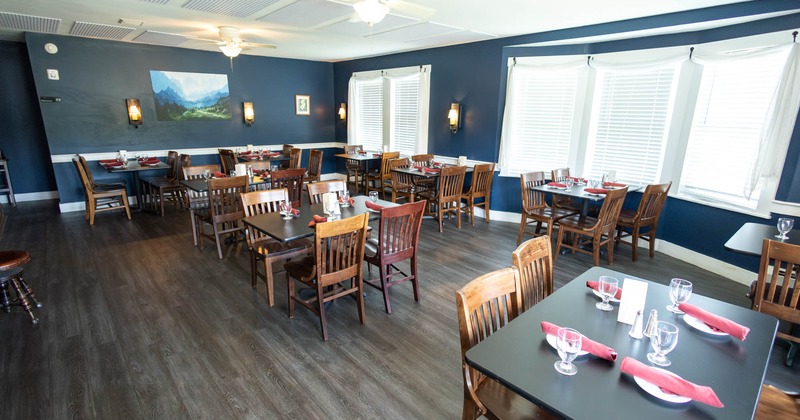 Interior, dining area, tables and chairs ready for guests, windows with closed blinds