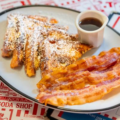 French toast dusted with powdered sugar, serve with bacon and maple syrup.