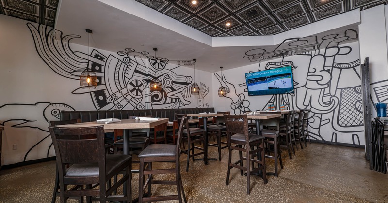 Modern restaurant interior with abstract wall mural and seating, TV on the wall