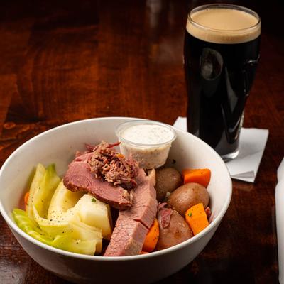 Corned Beef & Cabbage with boiled potatoes and carrots, with sauce and dark beer