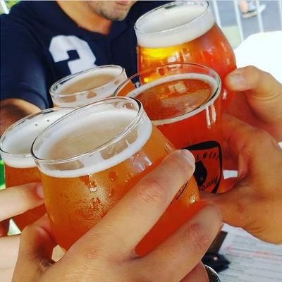 multiple hands holding glasses togehter.