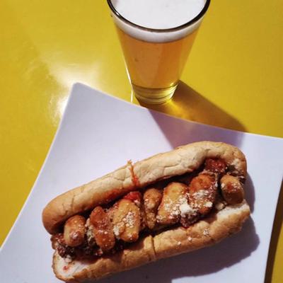 Chicken Parmesan sandwich served with a glass of beer.