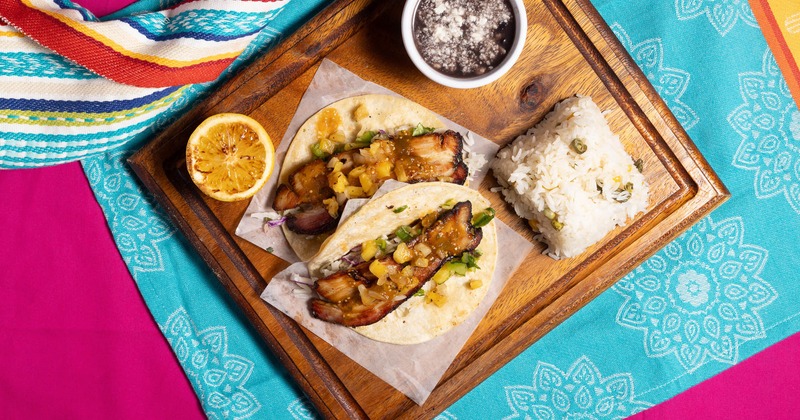 Pork belly tacos with rice, beans, and charred lemon