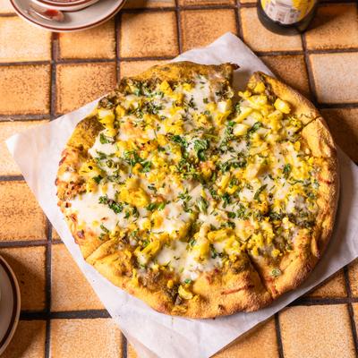 Indian Veggie Pizza served on a tiled table.