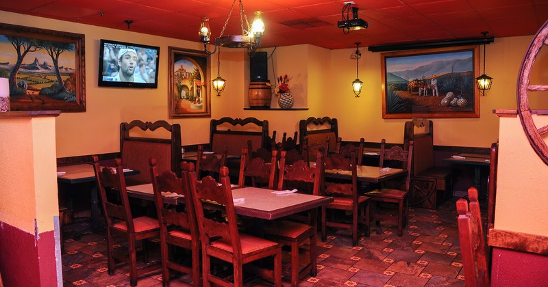 Interior, dining booths and table, paintings depicting rural life on walls