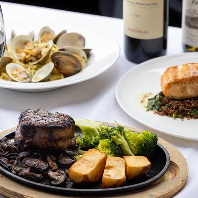 Grilled steak with mushrooms, potatoes, and broccoli, served with clams and salmon.