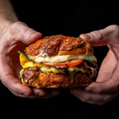 Hands holding the hero's sandwich.