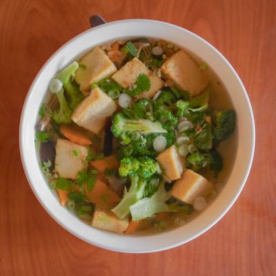 Vegetarian pho noodle soup with fried tofu, broccoli, carrots, fried onions, and mushrooms.