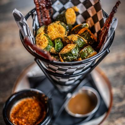 A basket of hand breaded jalapenos with candied bacon, served with dipping sauces.
