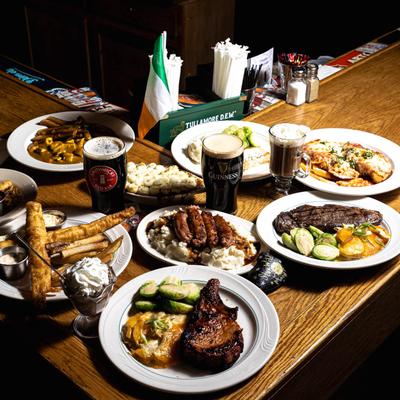Variety of dishes sered on a counter alongside drinks and the small Irish flag.