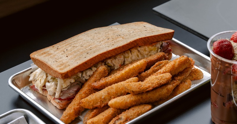 Sandwich served alongside seasoned fries