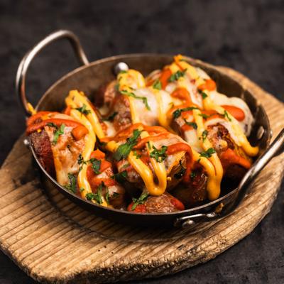 Patatas bravas with melted mahon cheese and spicy roasted tomato aioli.