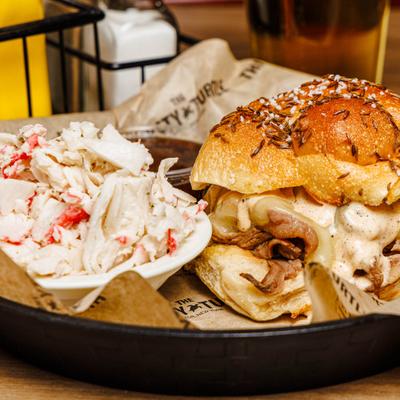 Beef on Weck sandwich with sautéed onions and mushrooms and coleslaw on the side.