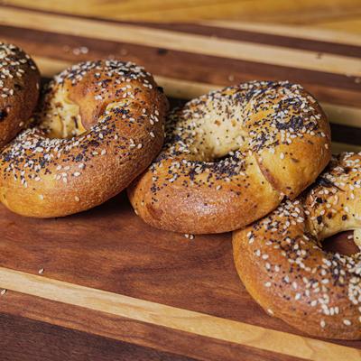 Bagels with sesame and poppy seeds on a wooden table.