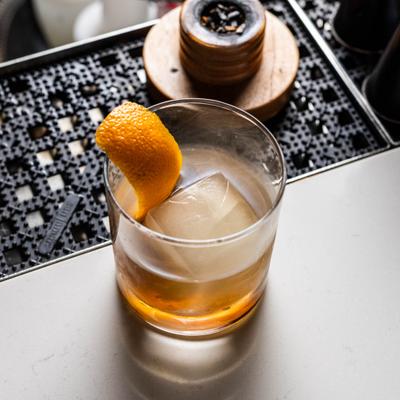 Smoked Old Fashioned cocktail garnished with a orange peel.