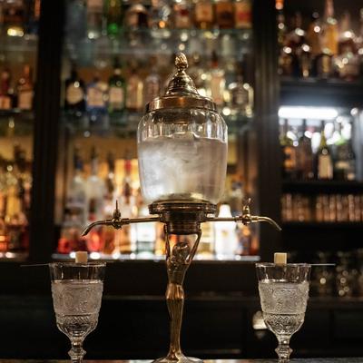 Absinthe container on the bar with glasses.