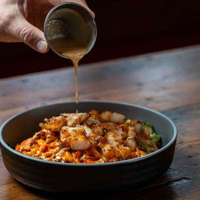 Asian Bowl with shrimp, being topped with dressing.