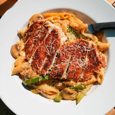 Cajun Chicken Pasta featuring blackened chicken breast sliced over penne.