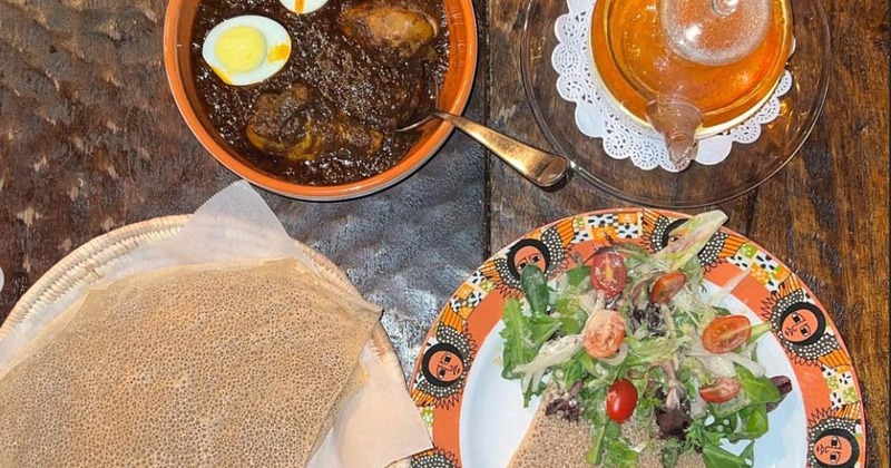 Ethiopian spiced chicken, doro wat, served with injera bread, salad, and tea