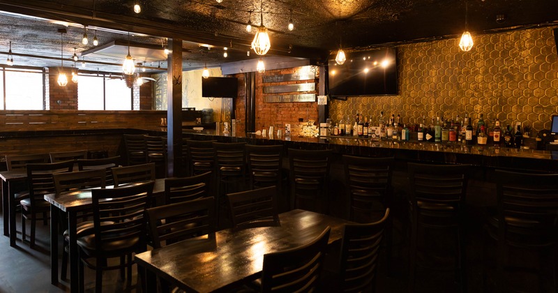 Interior, tables and chairs in seating area near bar