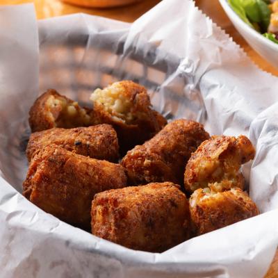 Cheddar Bacon Potato Kegs served in a basket lined with paper.