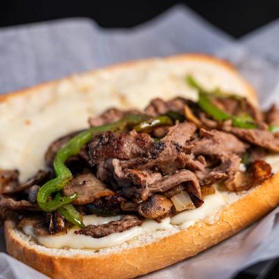 Philly cheesesteak sandwich with mushrooms, onions, green peppers, and mozzarella cheese.