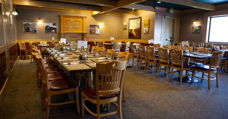 Long tables with chairs and tableware waiting for the guests