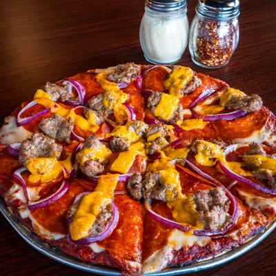 The Sharp Dressed Man Pizza served alongside glass condiment shakers.