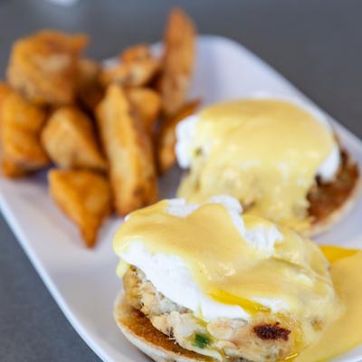 Eggs Benedict served with potato wedges.