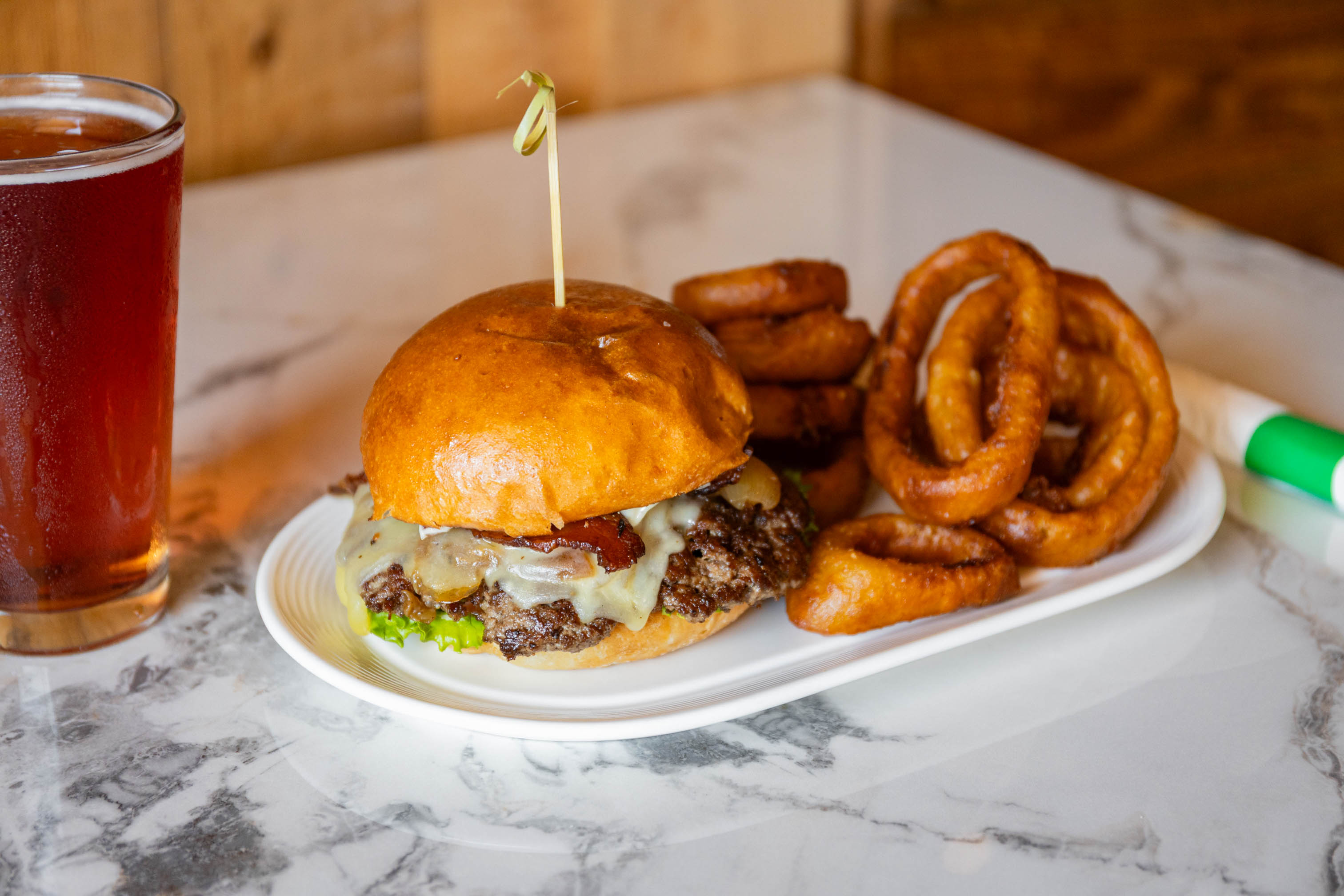 Don't Go Bacon My Heart burger served alongside thick onion rings