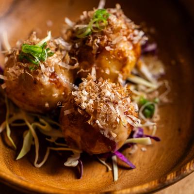 Close-up of fried octopus balls topped with bonito flakes.