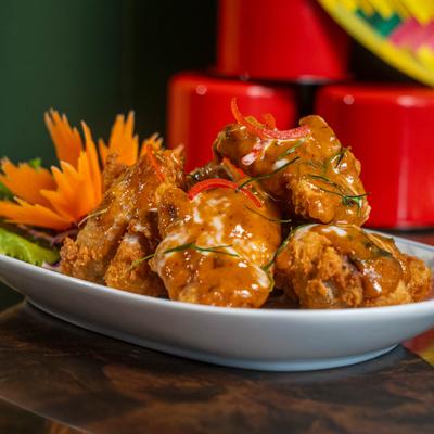 Crispy Thai chicken wings drizzled with aromatic spiced sauce and coconut cream.