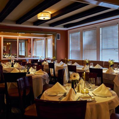 Warm dining room with tables set for guests.