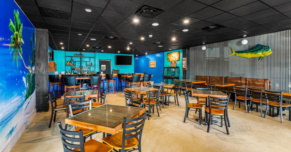 Interior, seating area, bar with bar stools in the back, decorated walls